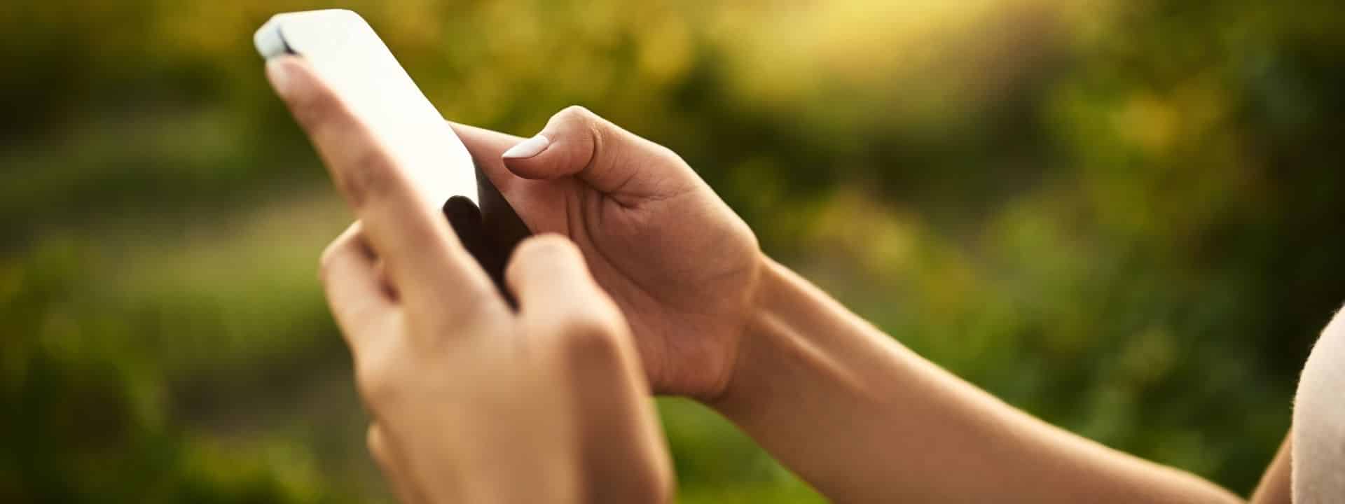 Frau hält Smartphone in der Hand und tippt etwas
