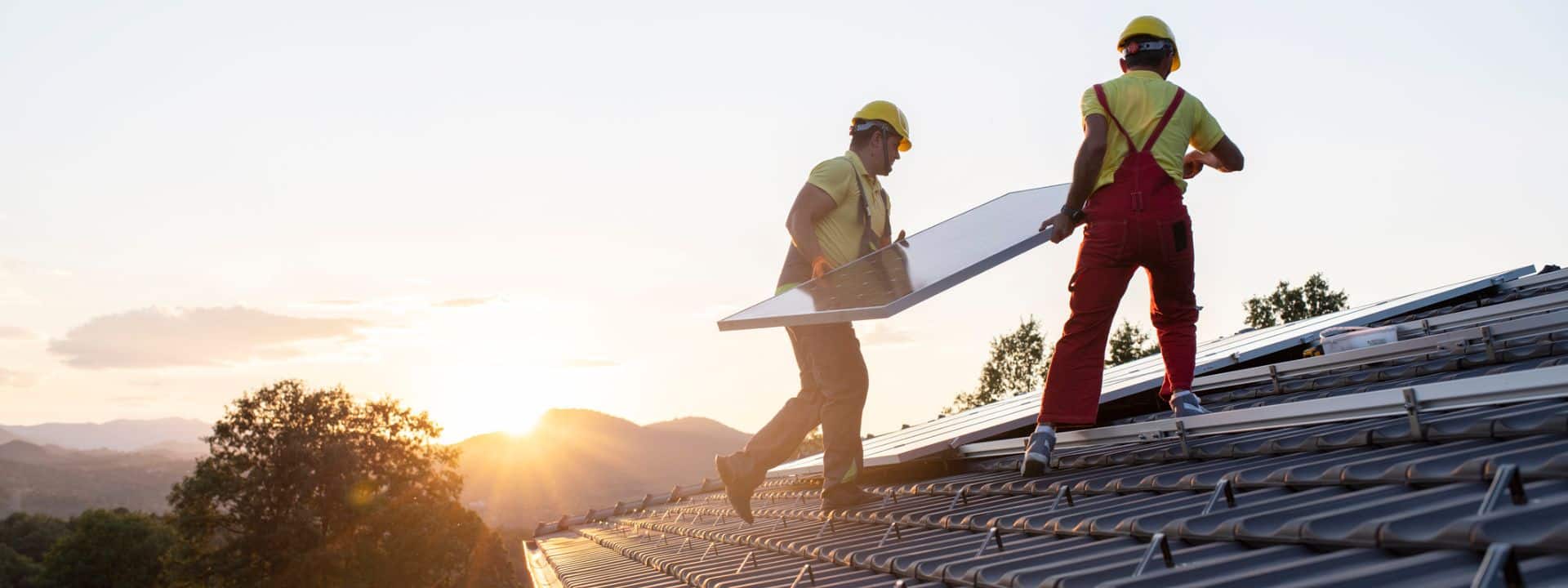 Zwei Handwerker installieren eine Solaranlage auf dem Dach