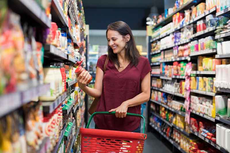 Frau im Supermarkt schaut sich ein Produkt an