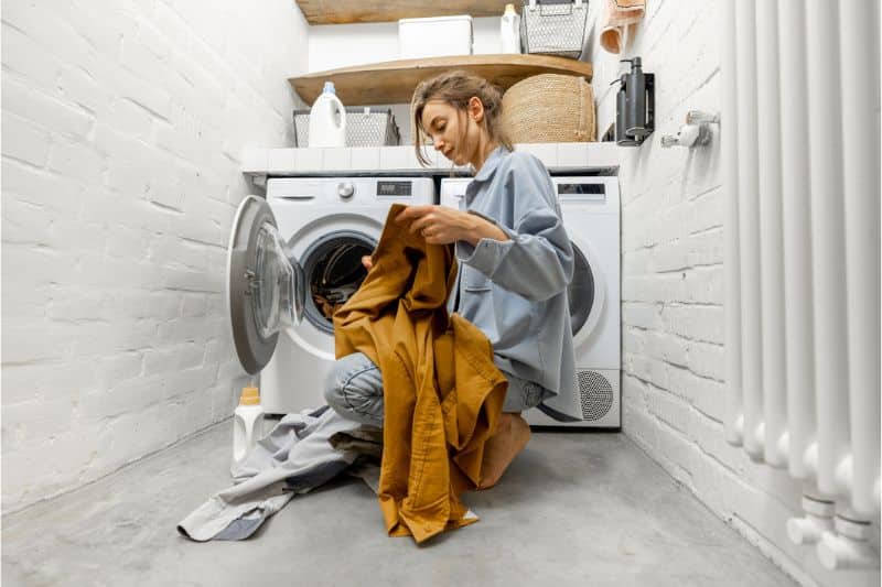 Junge Frau bestückt die Waschmaschine