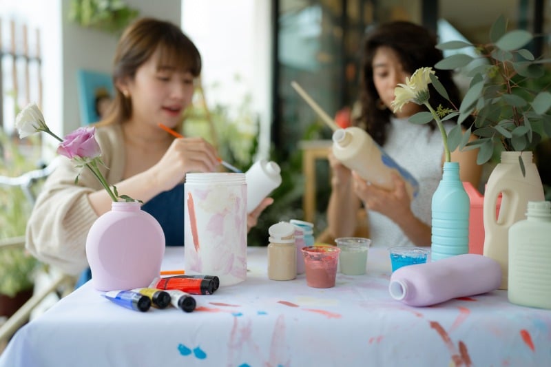 Zwei Frauen gestalten alte Plastikverpackungen als Vasen