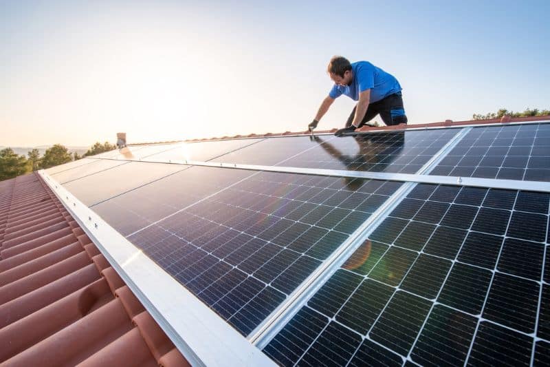 Arbeiter installiert Solarmodule auf dem Dach