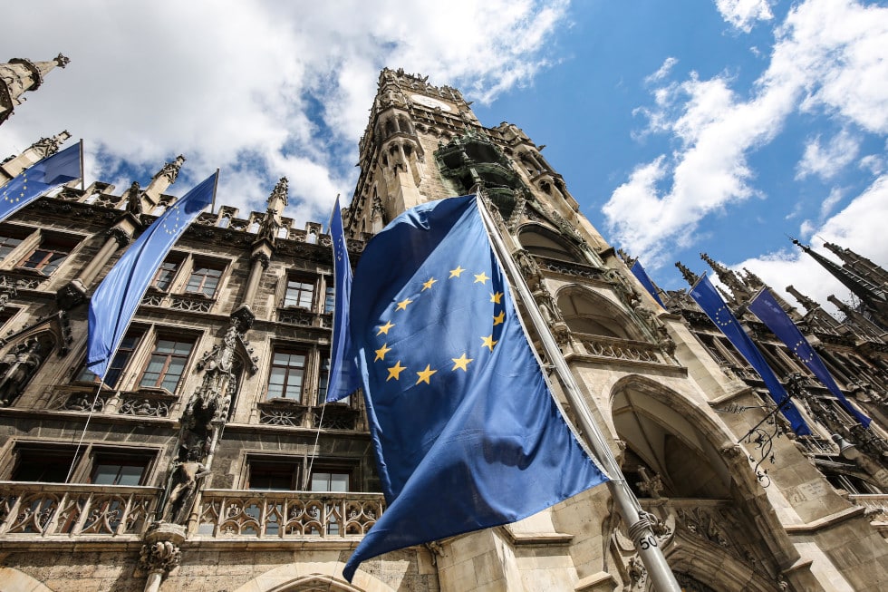 EU Flaggen wehen vor dem neuen Rathaus in München im Wind.