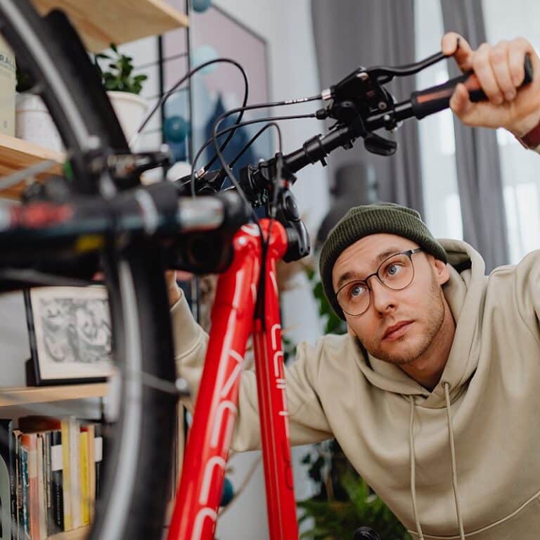 Mann überprüft Bremsen und Reifen eines Fahrrads