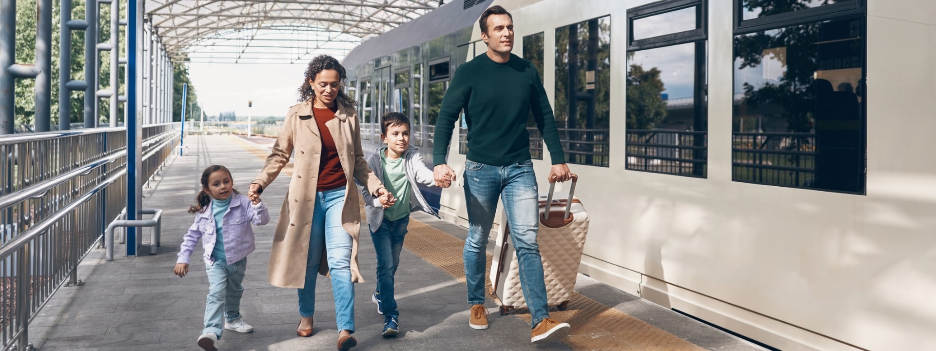 Familie mit Koffer auf dem Weg zur Bahn